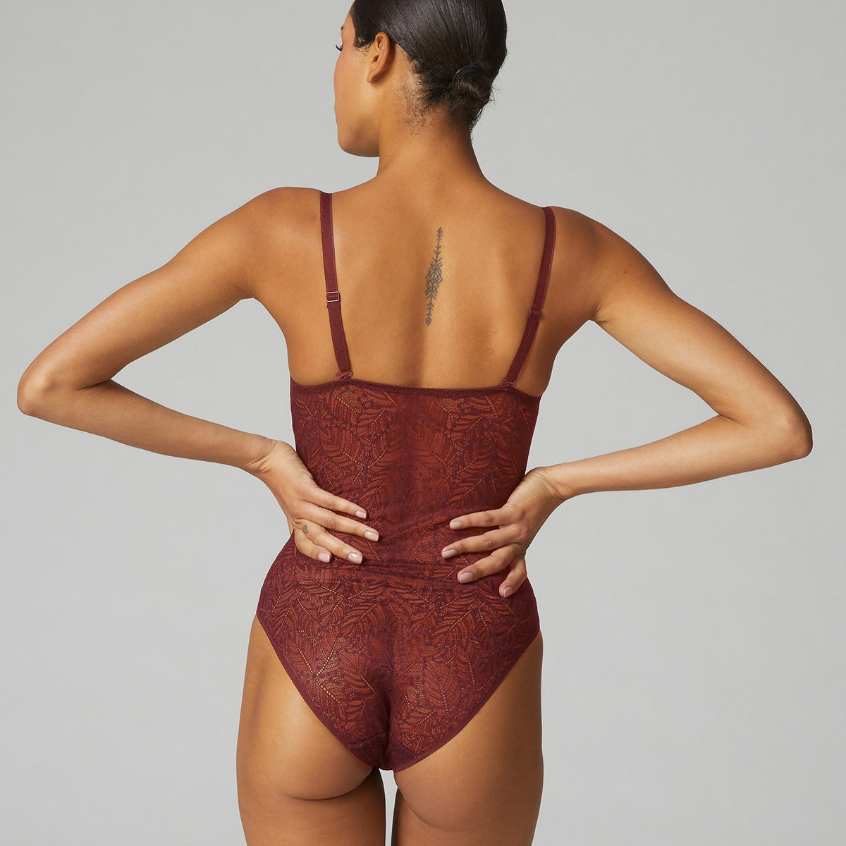 Back of Simone Perele Comete all over lace bodysuit in an amber red colour