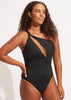 Woman wearing a black swimsuit with cut-out design on a white background