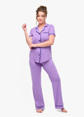 Woman wearing a purple pajama set on a white background