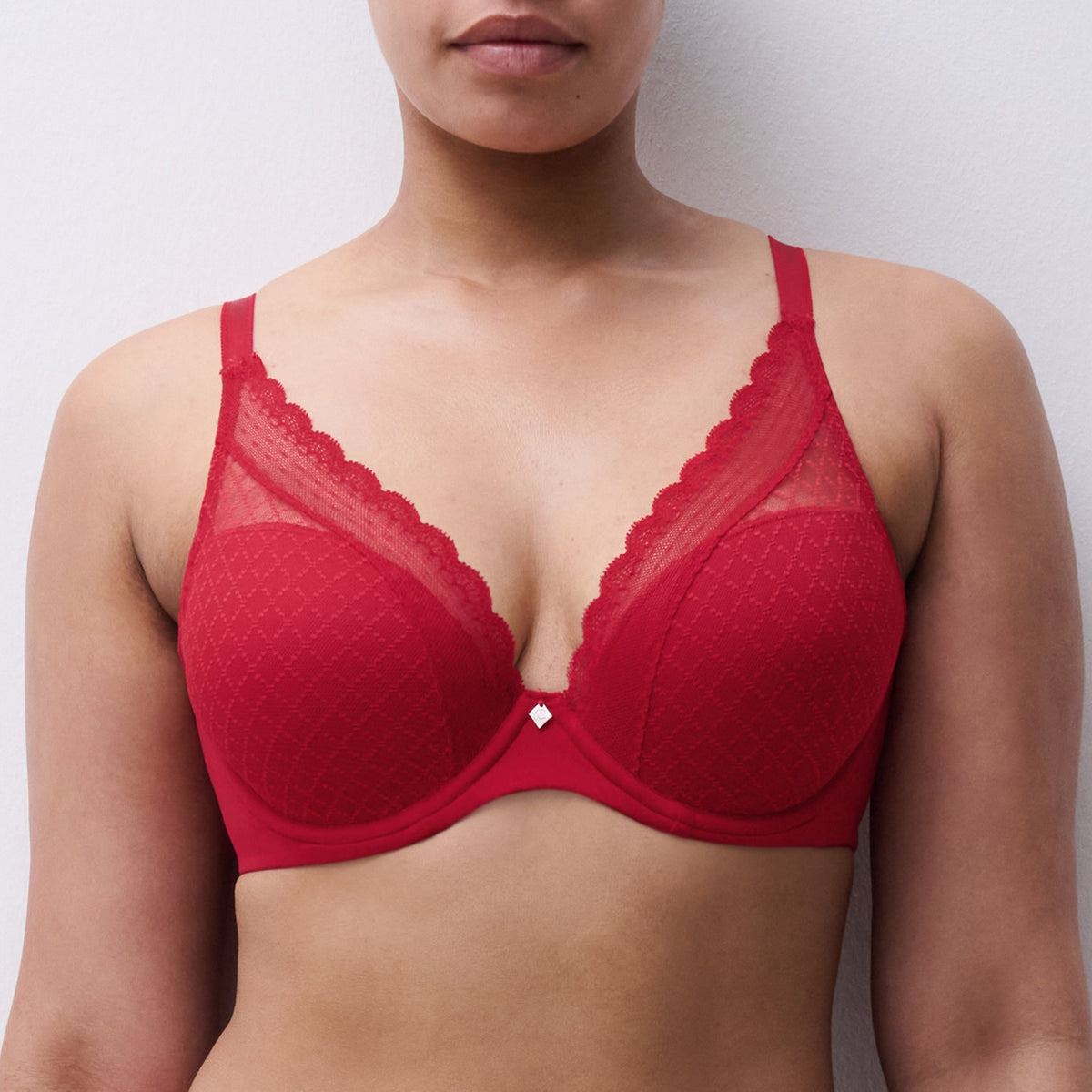 Woman wearing a red bra against a plain background