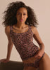 Woman wearing a leopard print tank top camisole against a beige background