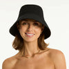 Woman wearing a black bucket hat and white bikini top on a white background
