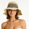 Woman wearing a white bikini top and a straw hat with a black band on a white background