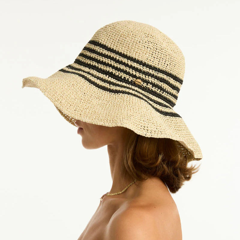 Woman wearing a straw hat with a black band on a white background