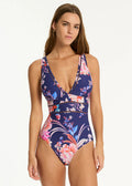 Woman wearing a floral one-piece swimsuit on a white background