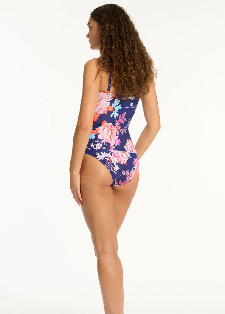 Back of woman wearing a floral one-piece swimsuit on a white background