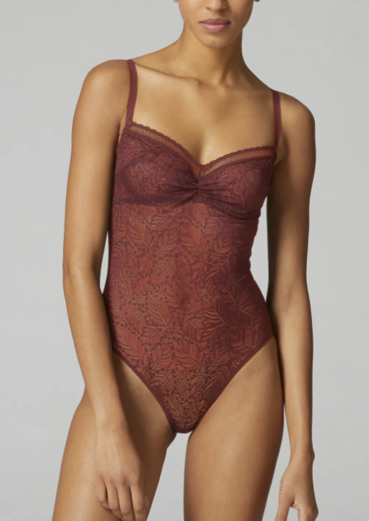 Side view of Simone Perele Comete all over lace bodysuit in an amber red colour